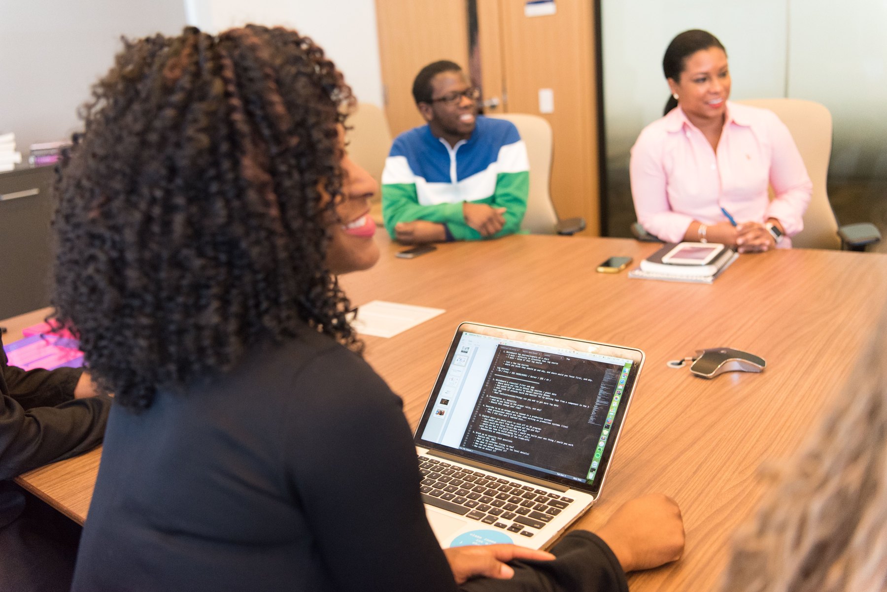 Software professionals collaborating around a laptop in a modern office